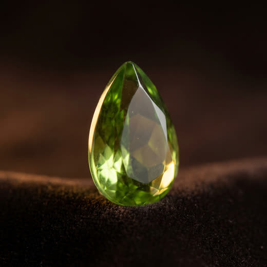 Green-tinted ash-crystal, faceted pear cut